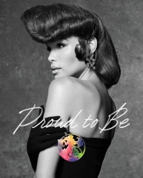 Model with structured retro bouffant hair and black gloves looking over shoulder against a textured studio backdrop.