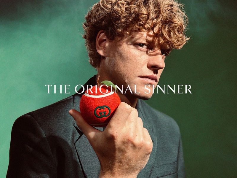 Jannik Sinner holding a red tennis ball with the Gucci logo for The Original Sinner campaign