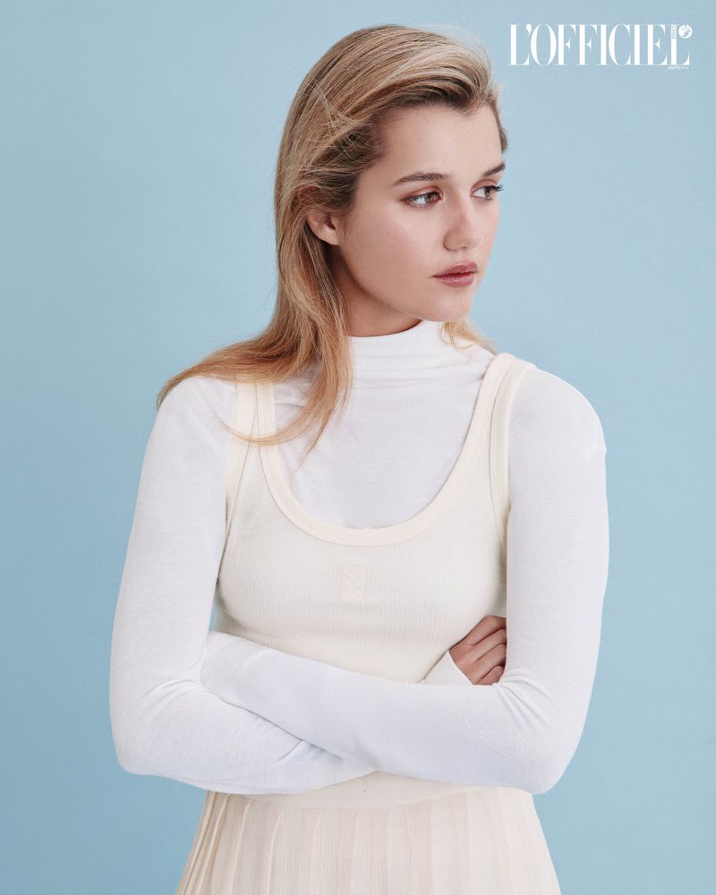 Fernanda Finsterbusch in a layered white turtleneck and ribbed tank top against a blue studio background for L'Officiel Chile.