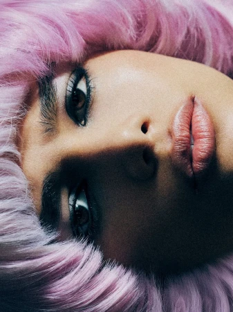 Close-up beauty portrait of model Aviana M framed by textured pastel pink and lilac hair.
