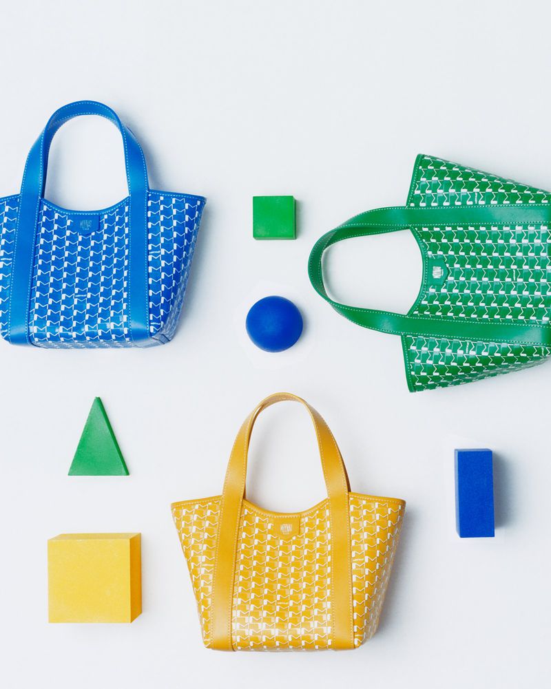 Three colorful patterned tote bags in blue, yellow, and green are arranged with geometric shapes on a white background.