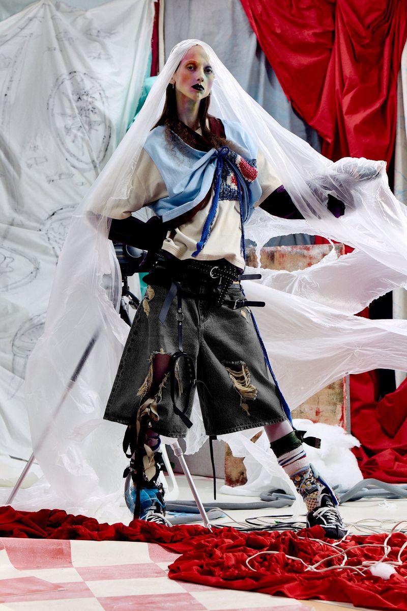 Model Zara Sands draped in white plastic veil and distressed denim shorts for Charles Jeffrey Loverboy lookbook.