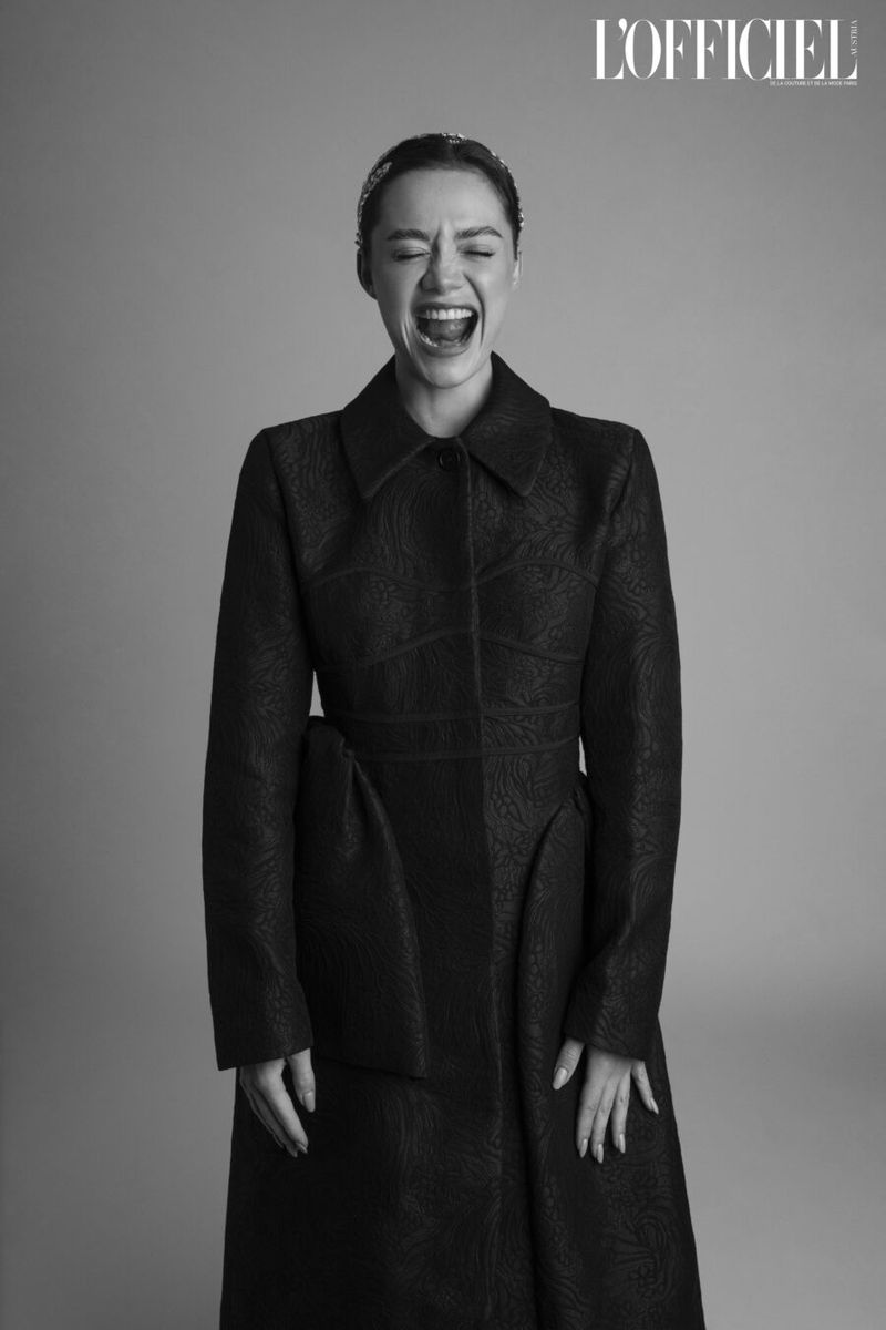 Black and white portrait of a screaming woman wearing a patterned black coat against a plain background, with magazine logo visible.