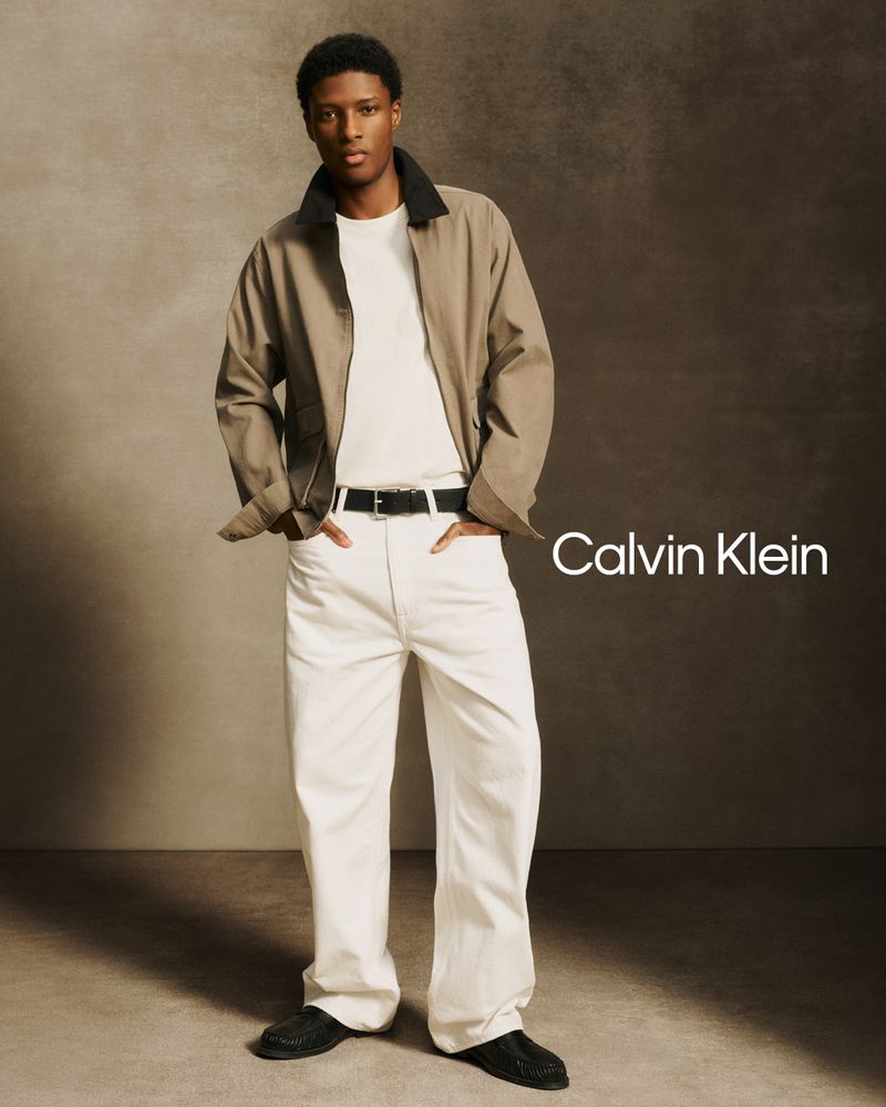 Model Aboubakar Konte in a khaki utility jacket and wide-leg white pants posing for Calvin Klein.