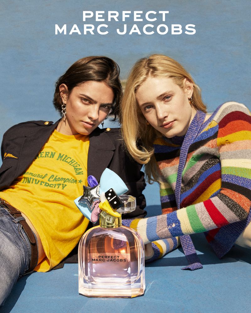Two female models posing with a perfume bottle on a blue background for Marc Jacobs Perfect campaign