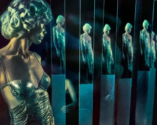 Model in a metallic ruched dress in profile with repeating reflections across vertical mirror panels.