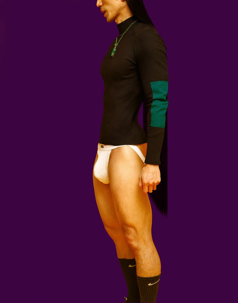 Side profile studio shot of an adult male with long hair wearing a black long-sleeve shirt and white jockstrap against a purple backdrop.