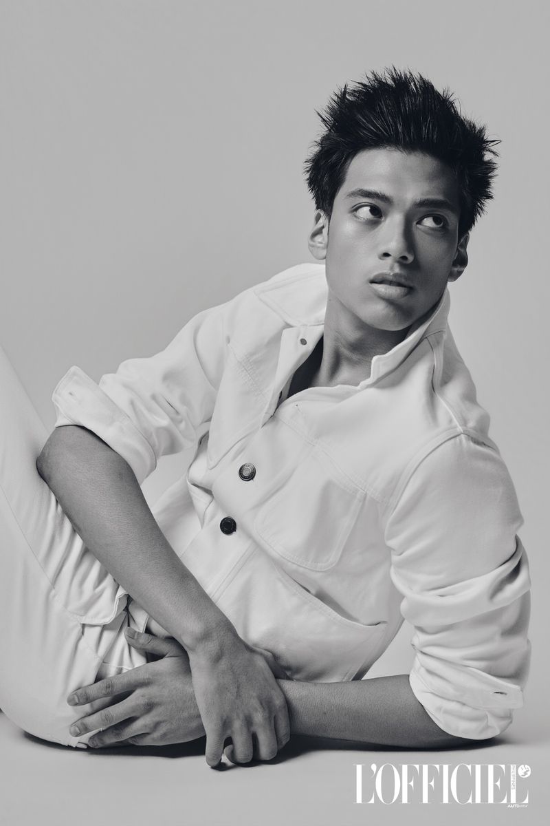 Filipino male model reclining on the floor wearing a white buttoned jacket for L'Officiel Philippines.