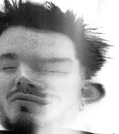 Monochrome distorted close-up portrait of Adam Lambert with spiky hair and closed eyes against a bright background.