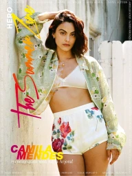 Camila Mendes posing in a green floral jacket, white bralette, and floral shorts for HERO Summer Zine cover.