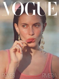 Model Lennon Sorrenti eating a pink popsicle on the Vogue France cover, wearing a pink tank top and ornate gold chandelier earrings.