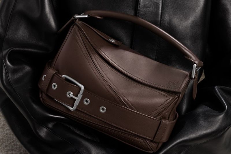 Brown leather Loewe handbag with silver hardware on black leather. Close-up shot in studio lighting showcasing fashion accessory.