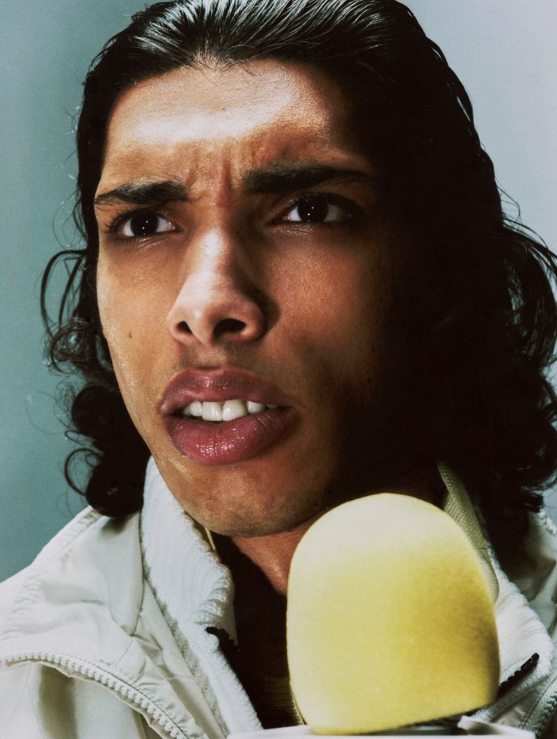 Close-up portrait of a man speaking into a yellow microphone for The Press Conference project by Circle Zero Eight.