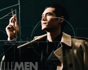 Model Hao Yun Xiang in a tan coat holding a pen against architectural line drawings for Elle Men China
