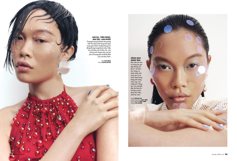 Close-up of an Asian female model in a red, beaded top and short, wet hair with stickers, promoting beauty and fashion.