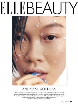 Close-up of a woman's face with skincare dots on her skin, featured on the cover of Elle Beauty magazine. Beauty concept.
