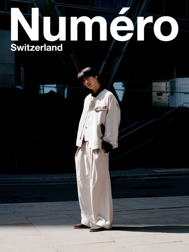 Model Sanggun Lee poses outdoors in an oversized cream two-piece suit and dark shoes for Numéro Switzerland.