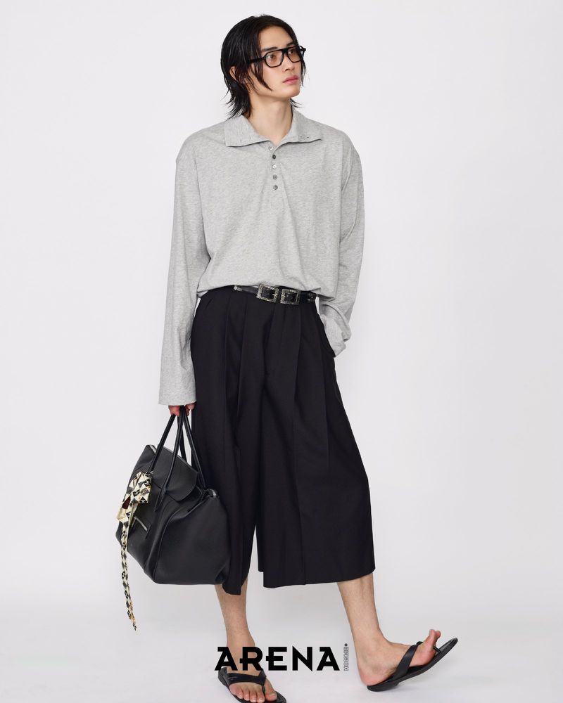 Model Jinyeong Pak posing in a light grey long-sleeve polo shirt, black wide-leg culottes, and black sandals against a white background.