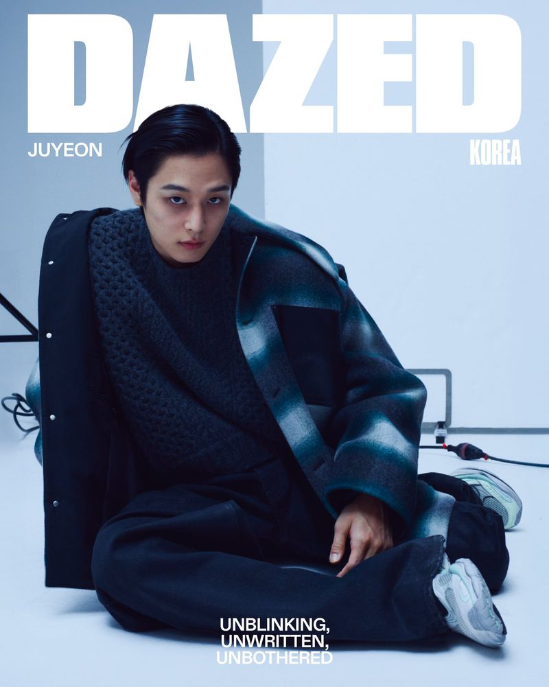 Juyeon seated on a studio floor in an oversized coat for Dazed Korea magazine cover.