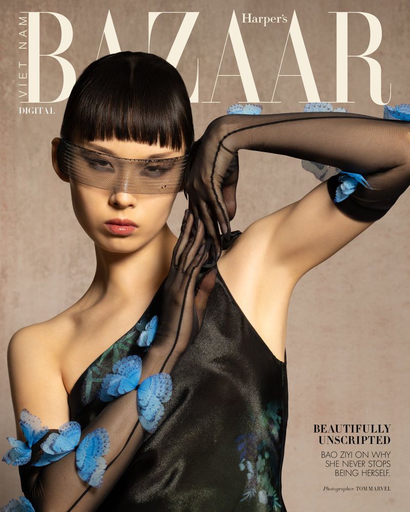 Model Bao Ziyi wearing sheer black gloves with blue butterfly appliqués and a mesh eye veil for Harper's Bazaar Vietnam.