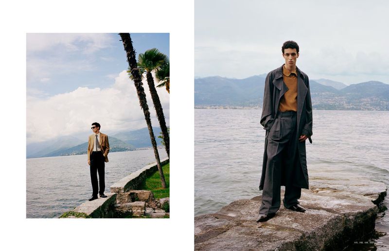 Two stylish adult males pose by scenic lakes under cloudy skies, showcasing contemporary menswear fashion and natural outdoor beauty.