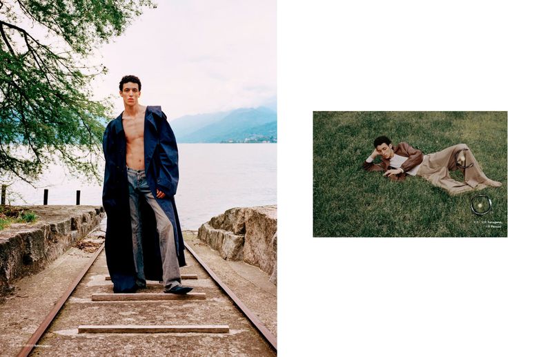 A fashion editorial with two young men posing outdoors. One is standing by a lake and the other is lying on a grassy field.