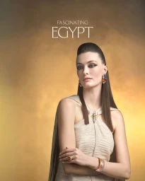 Model Jace Higgins posing in fine jewelry and a cream halter dress against a warm golden background with Fascinating Egypt typography.