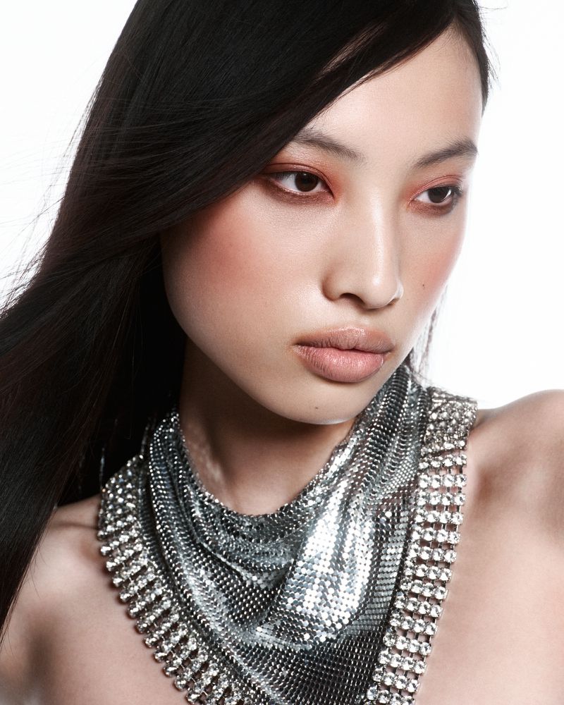 Model Mengyao Wang wearing a silver chainmail and rhinestone bib necklace against a bright white background.