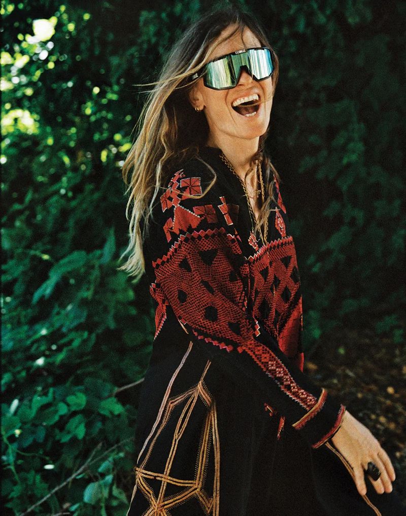 Model Nataša Vojnović wearing mirrored sunglasses and an embroidered black coat outdoors for Vogue Adria