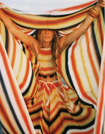 Model Nataša Vojnović holding a wide striped patterned textile framing her face for Vogue Adria.