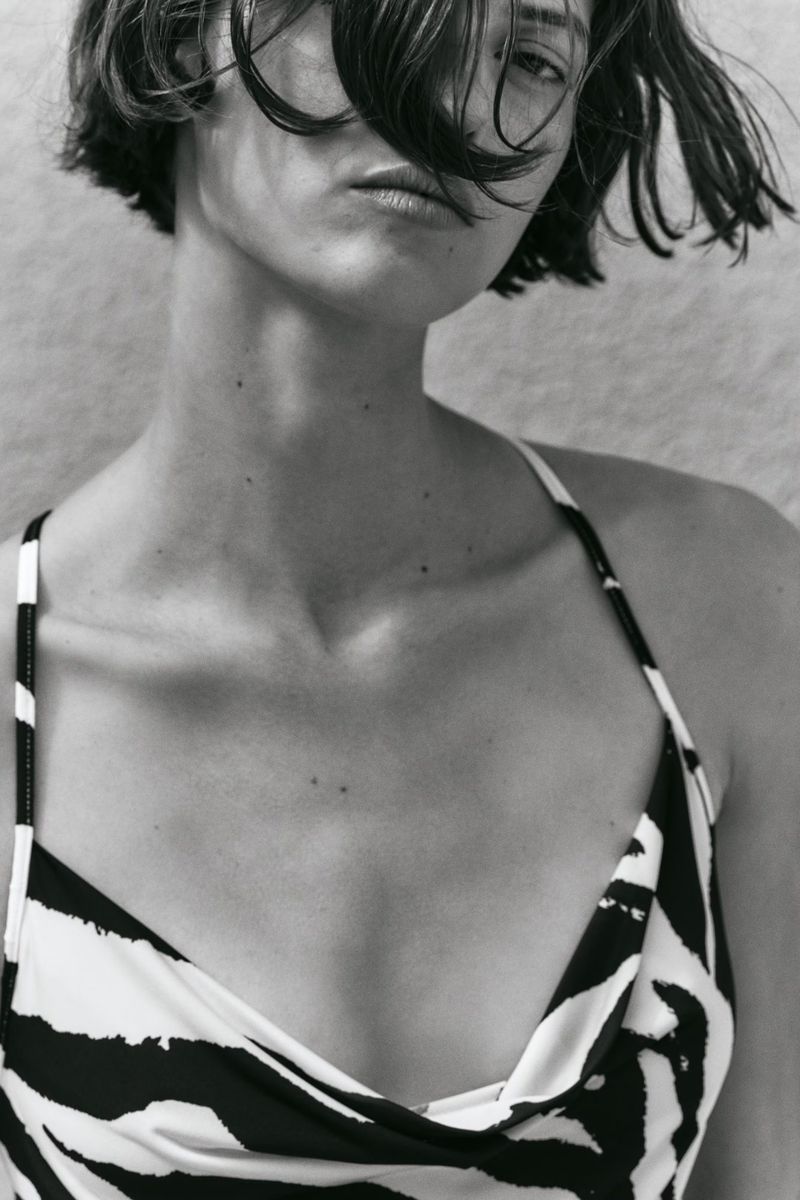Close-up black and white portrait of model Valerie Scherzinger wearing a zebra print swimwear top with thin straps.