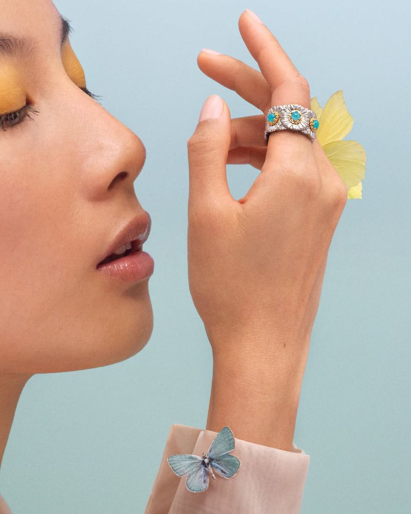Close-up profile of model Kate Tsai showcasing an ornate turquoise and silver Buccellati ring against a soft blue backdrop.