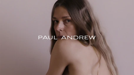 Model Laura Morgan looking over a bare shoulder against a neutral backdrop with Paul Andrew branding text across the frame.
