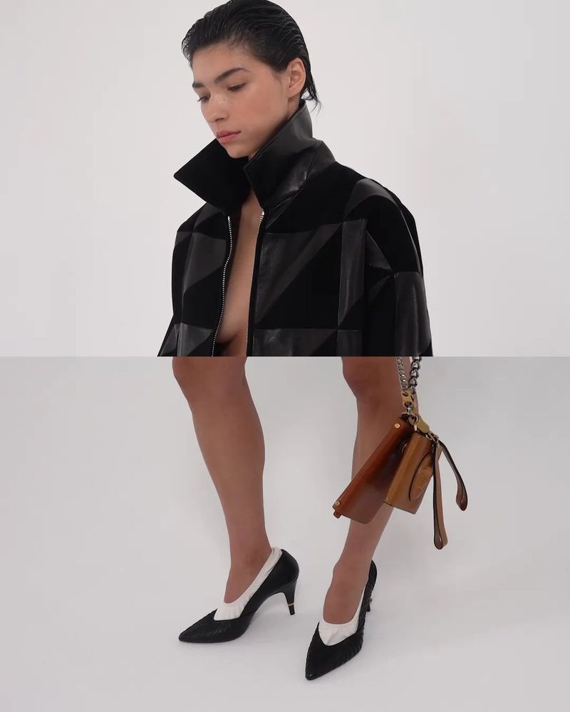 Surreal fashion composite of a woman wearing a high-collar black jacket aligned with bare legs in two-tone heels against a white backdrop.