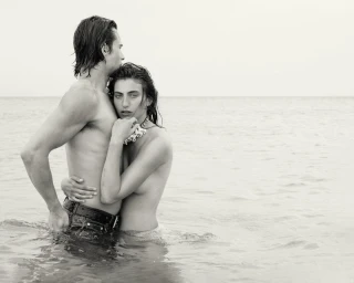 Monochrome image of a male and female model standing in shallow ocean water for Venroy Mallorca 2025 campaign.