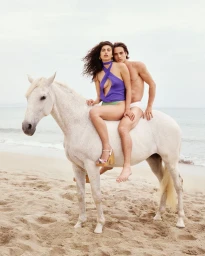 Paola Manes and Louis Baines ride a white horse along a sandy beach for the Venroy Mallorca 2025 campaign.
