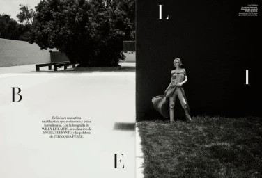 Belinda posing in a draped dress and trousers outdoors against dark architectural walls for Vogue Mexico.