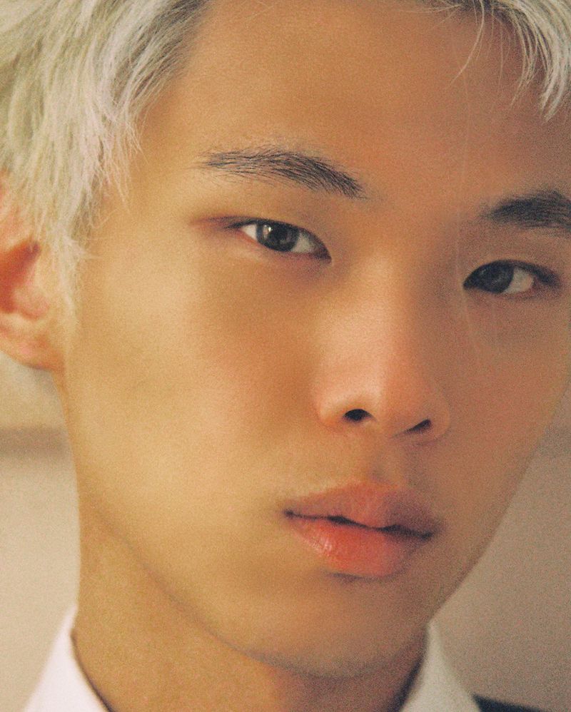 Close-up portrait of model Junseo Kim with platinum blonde hair and a white collar for The Greatest Magazine.