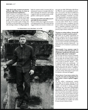 Black and white portrait of a man in a dark jacket posing outdoors against a weathered stone structure in a magazine editorial.