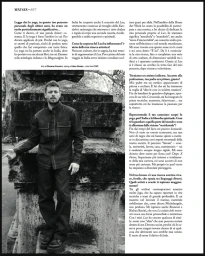 Portrait of Ludovico Tersigni standing outdoors next to a dark stone monument, wearing a dark button-up shirt and trousers, photographed in black and white by Simone Paccini for Next Gen.