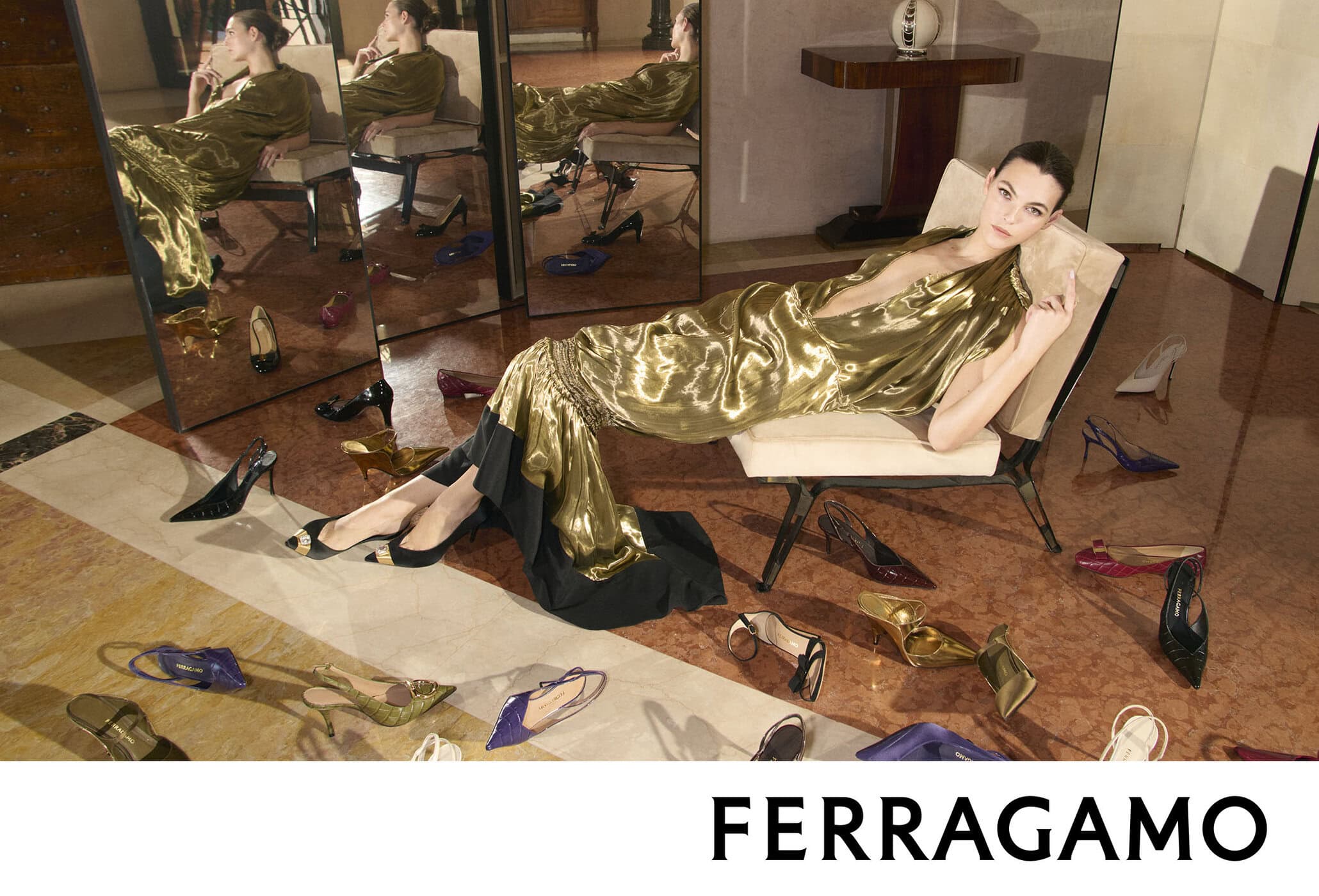 Vittoria Ceretti reclines in a metallic gold gown surrounded by scattered high-heel shoes in the Ferragamo Fall 2026 campaign.