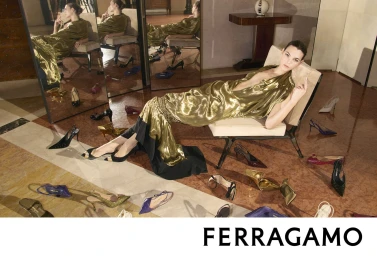 Vittoria Ceretti reclines in a metallic gold gown surrounded by scattered high-heel shoes in the Ferragamo Fall 2026 campaign.