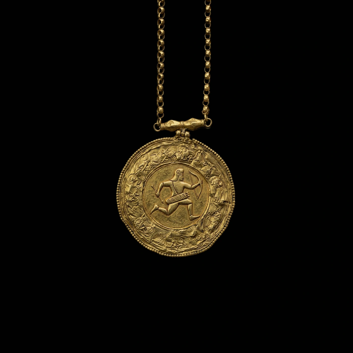 Engraved gold circular medallion pendant featuring an archer relief hanging on a link chain against a solid black background.