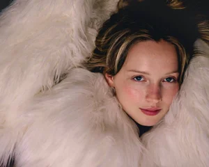 Close-up portrait of a woman surrounded by soft fluffy white faux fur garment for Sleek Magazine