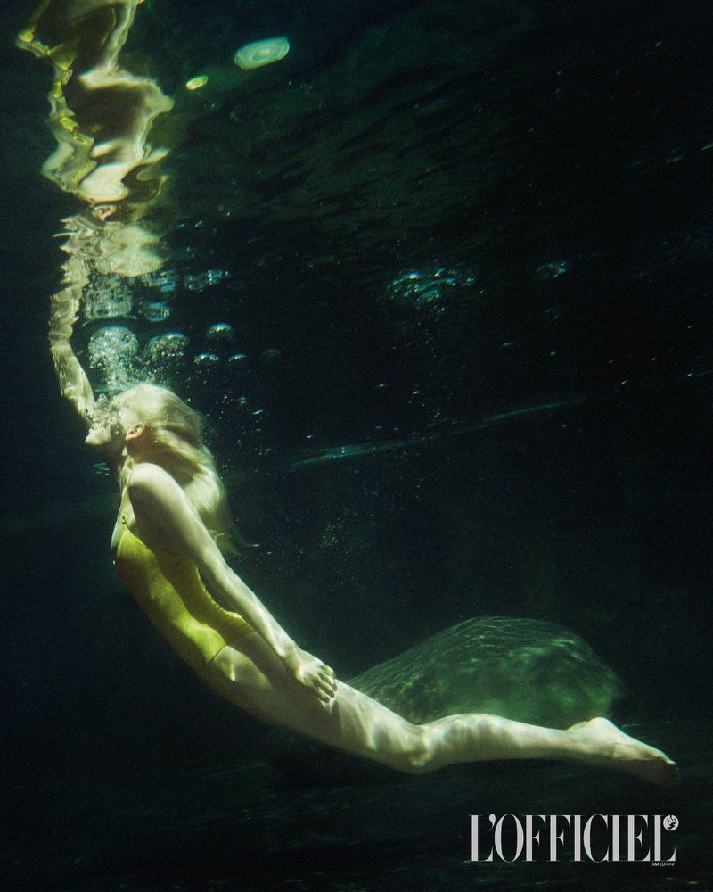 Model swimming underwater wearing a yellow swimsuit with air bubbles floating toward the surface for L'Officiel Italia Bali escape editorial
