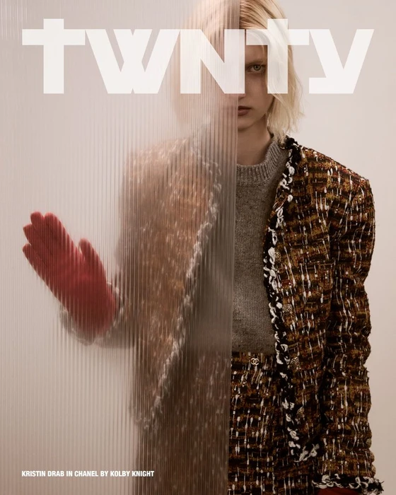 Kristin Drab poses behind a fluted panel in a Chanel tweed jacket and red glove for Twnty Magazine.