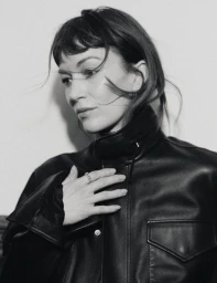 Actor Britt Lower in a black leather jacket looking to the side in a black and white editorial portrait for Flaunt.