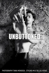 Black and white editorial portrait of shirtless model Francisco Rosso reaching his hands toward the camera against an ornate patterned rug.