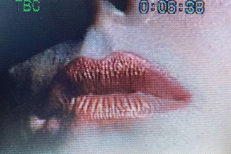 Close-up on a person's lips with visible texture detail, focus on the upper and lower lips, capturing the texture of skin and makeup.
