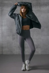 Model in grey sports apparel and matching jacket against a concrete wall for H&M Move Summerwear campaign